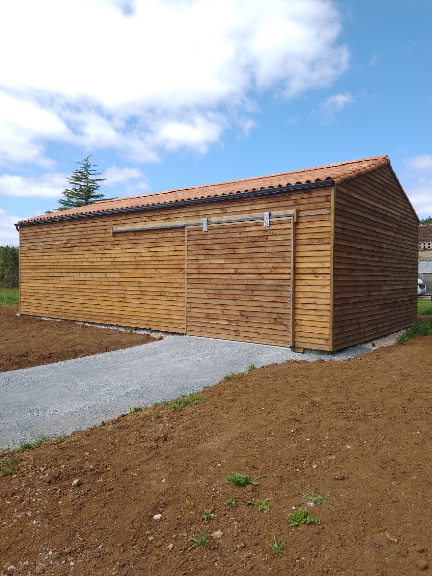 Garage en bois naturel, à proximité de la maison
